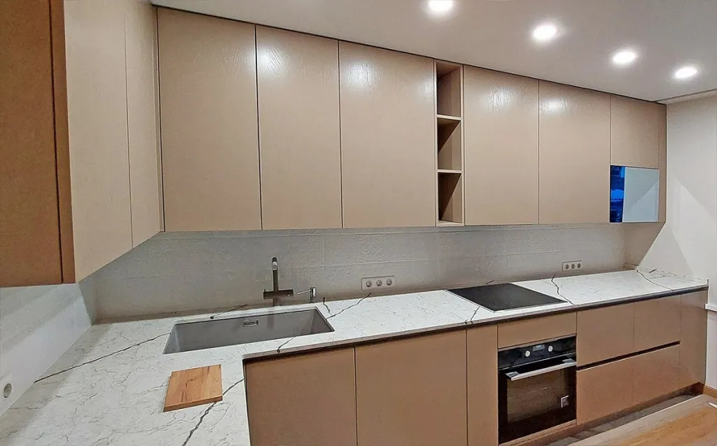 Beige kitchen with a mirror TV in the cabinet door