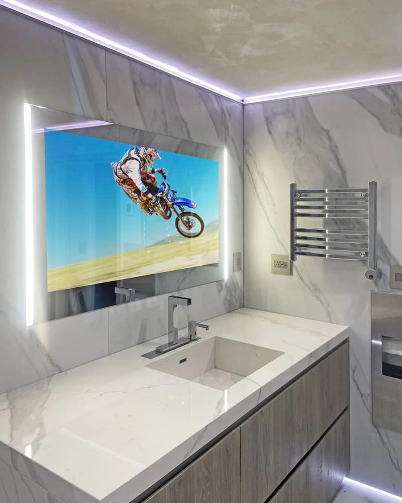 AVEL mirror TV above a bathroom sink with LED lighting