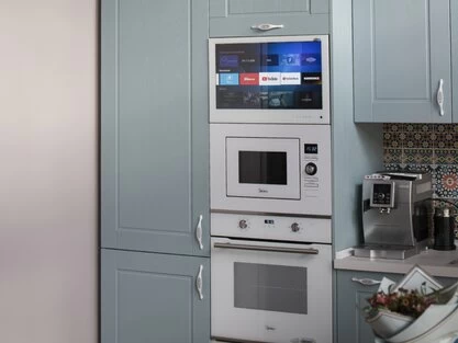 AVEL TV in a blue-grey kitchen cabinet above the microwave