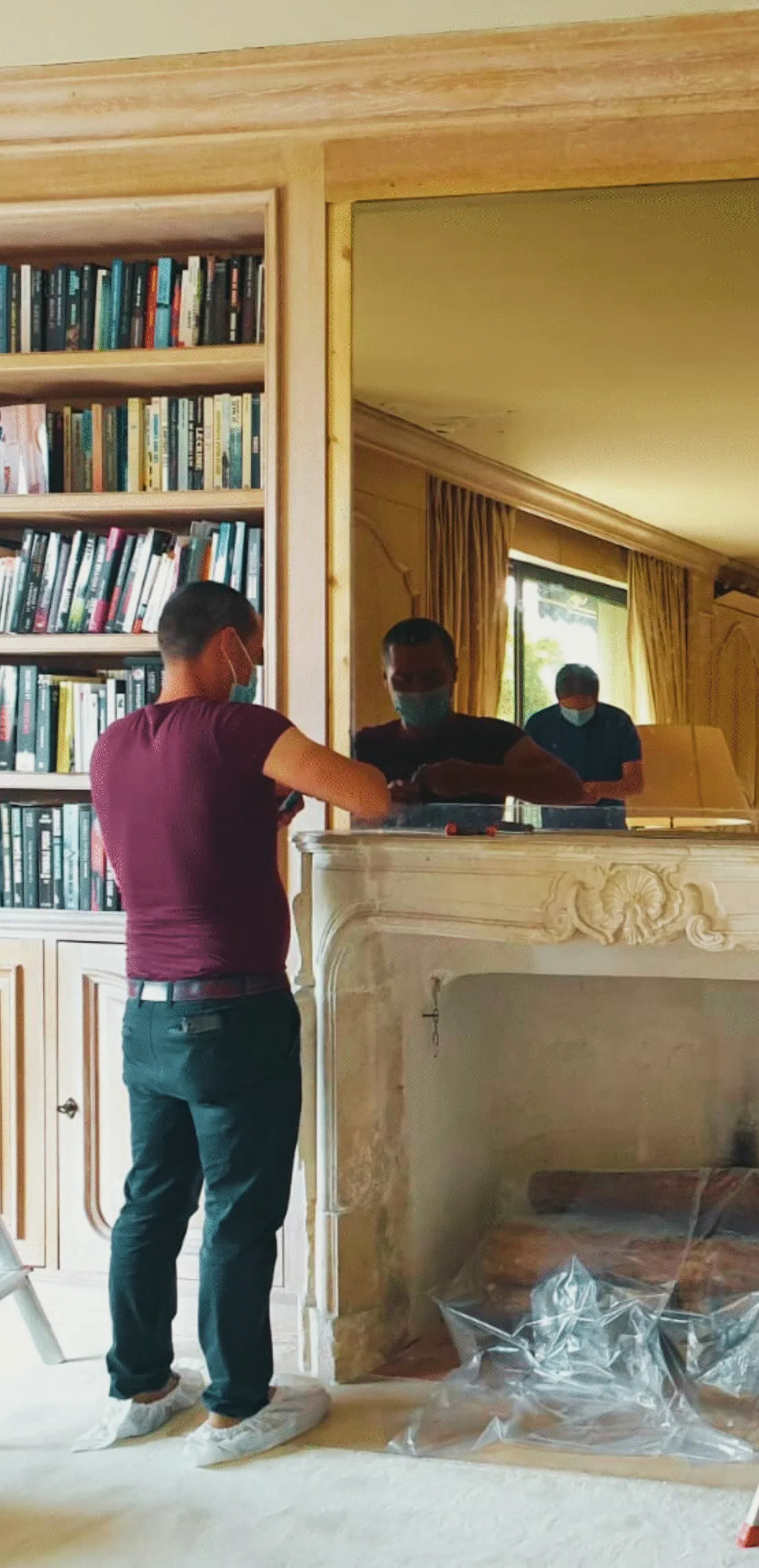 A man installing a mirror television in a living room