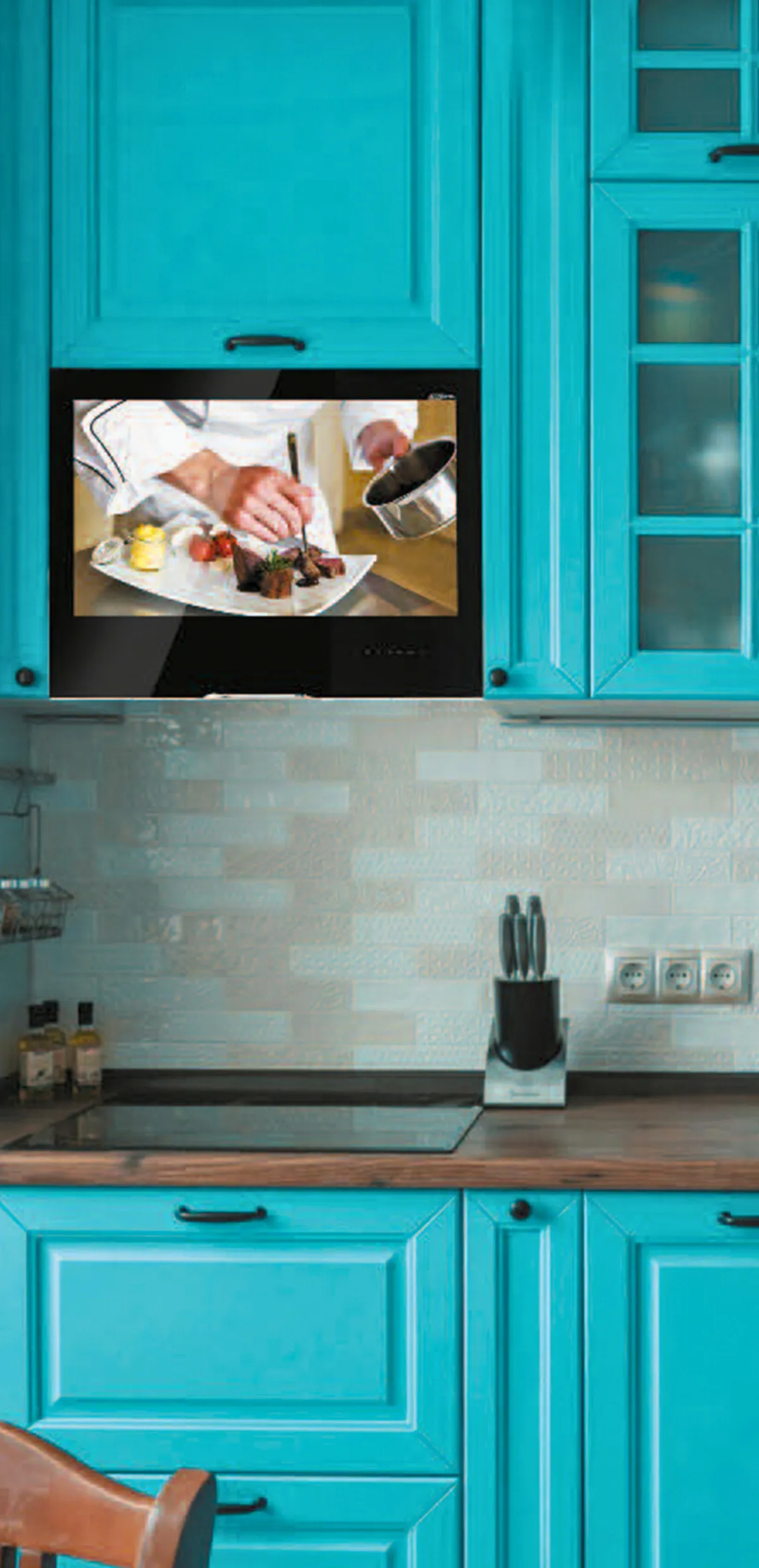 AVEL TV in a turquoise kitchen cabinet above the stove