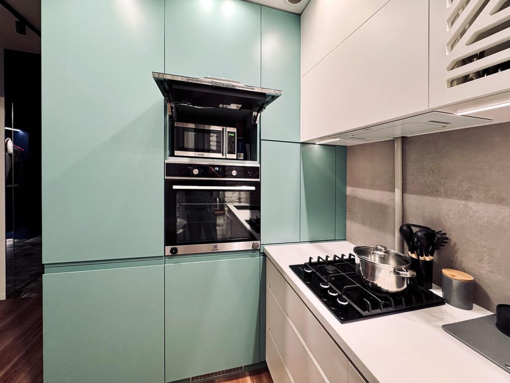 AVEL AVS240WS TV built into a mint green kitchen cabinet