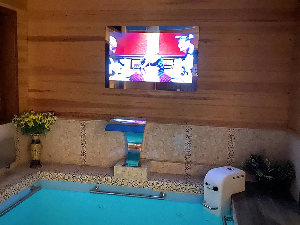 AVEL mirror TV above an indoor spa pool