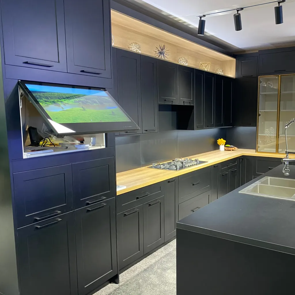 AVEL TV with a tilted door in a navy blue kitchen at KBIS 2024