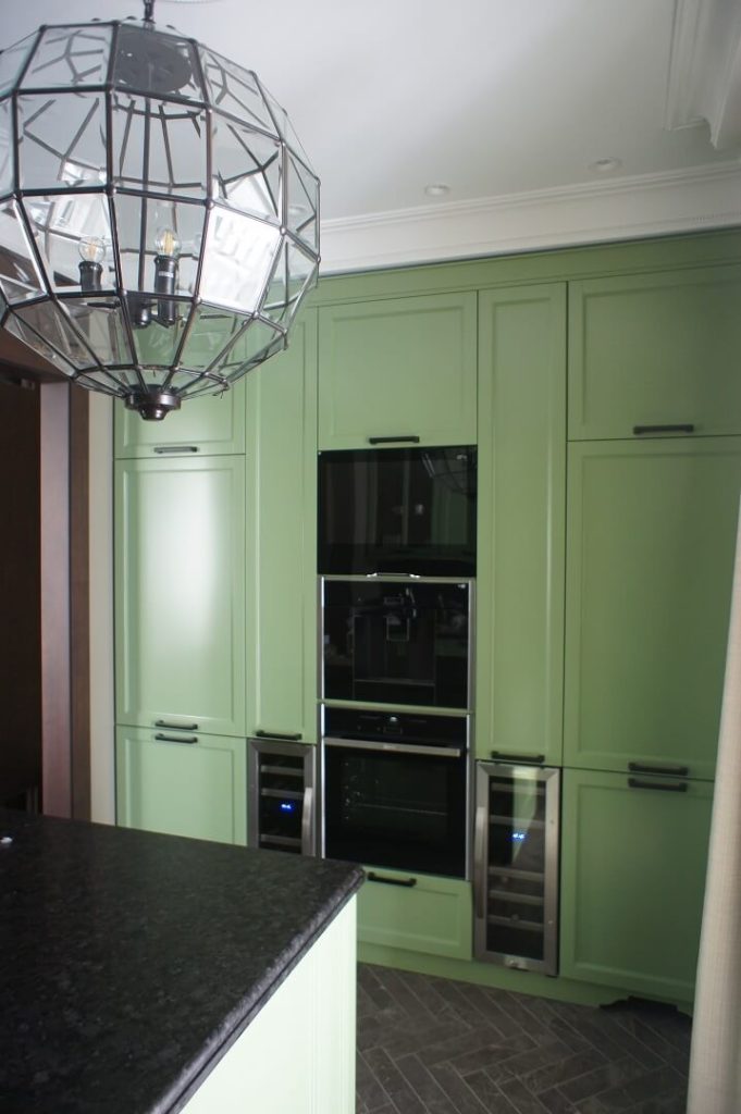 AVEL TV in green kitchen cabinets above the ovens