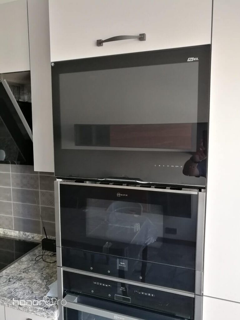 AVEL TV above an oven in a kitchen cabinet column