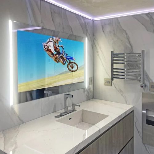 AVEL mirror TV above a bathroom sink with LED lighting